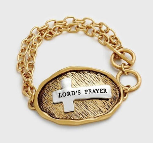 Gold tone toggle bracelet stamped with "Lord’s Prayer " on a silver tone cross on the front, and the Lord’s prayer stamped on the back