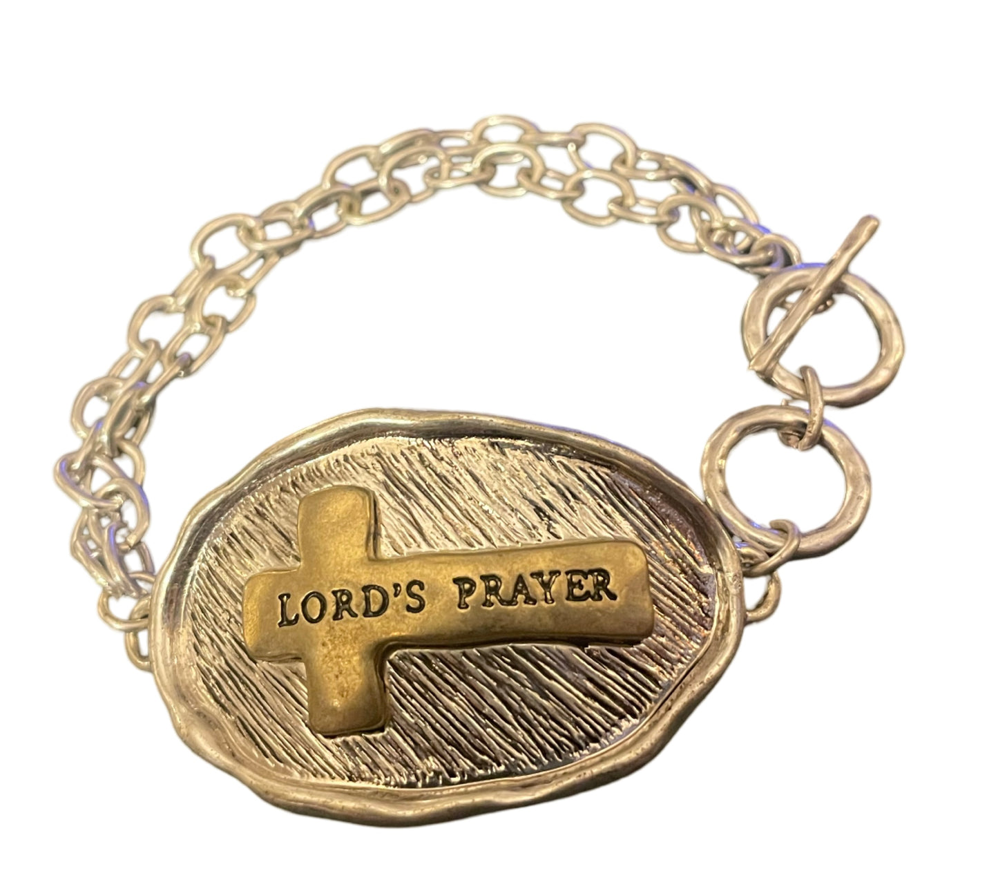 Silver tone toggle bracelet stamped with "Lord’s Prayer " on a gold tone cross on the front, and the Lord’s prayer stamped on the back