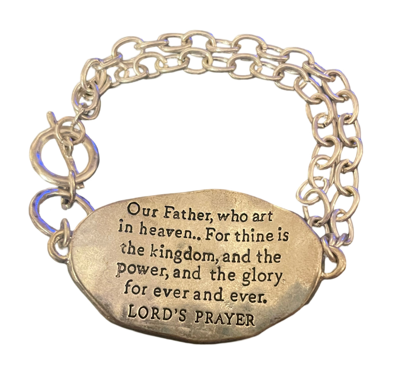 Silver tone toggle bracelet stamped with "Lord’s Prayer " on a gold tone cross on the front, and the Lord’s prayer stamped on the back