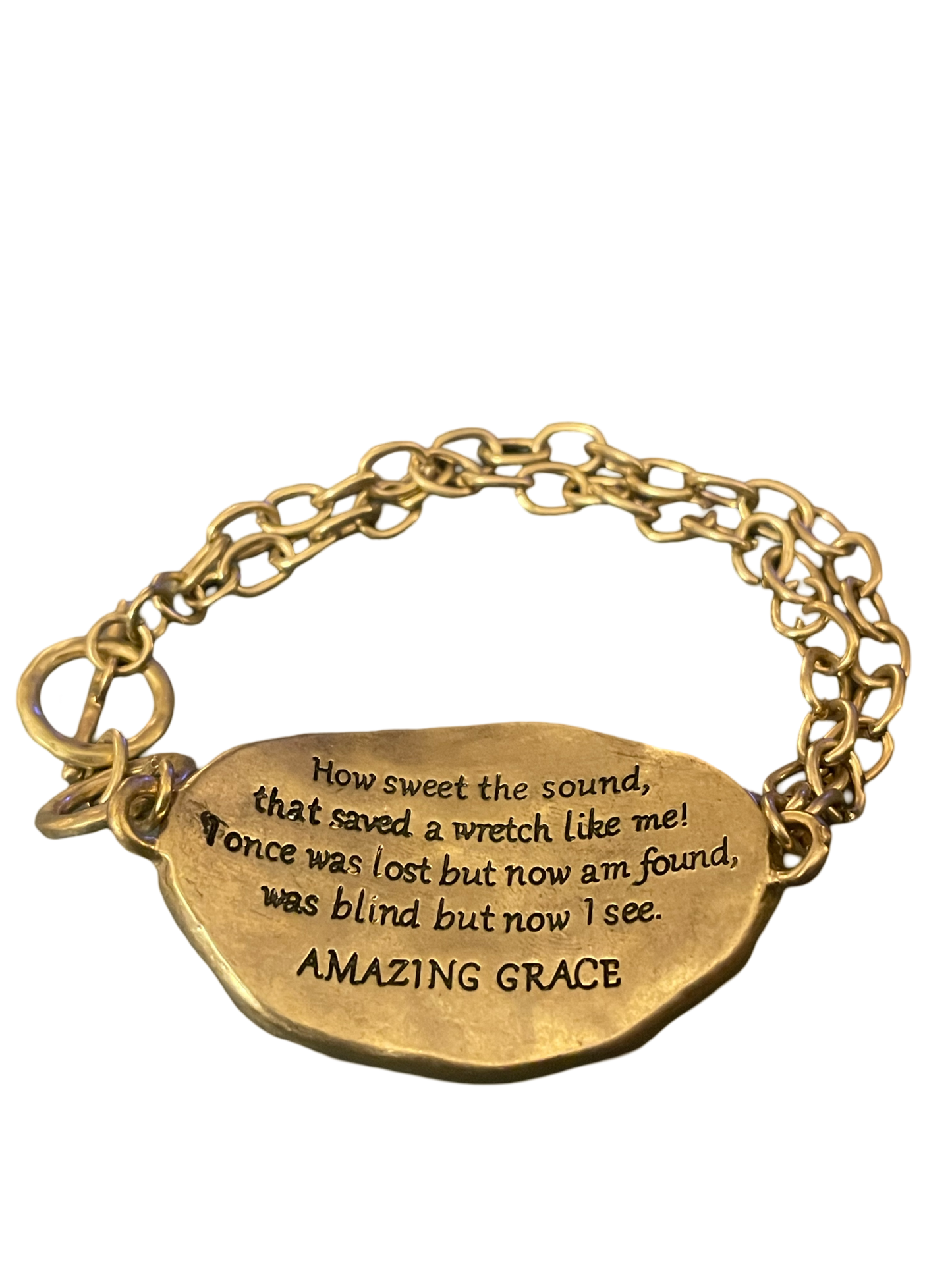 Gold tone toggle bracelet stamped with "Amazing Grace " on a silver tone cross on the front, and the words to Amazing Grace stamped on the back